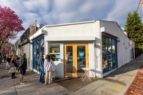 a small white building with a yellow door and blue windows