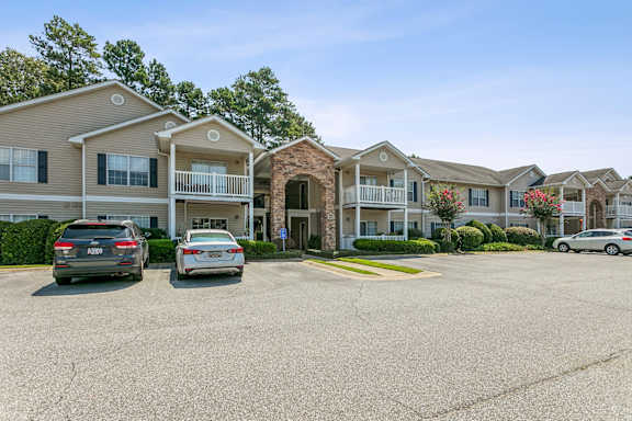 a parking lot in front of an apartment complex with cars