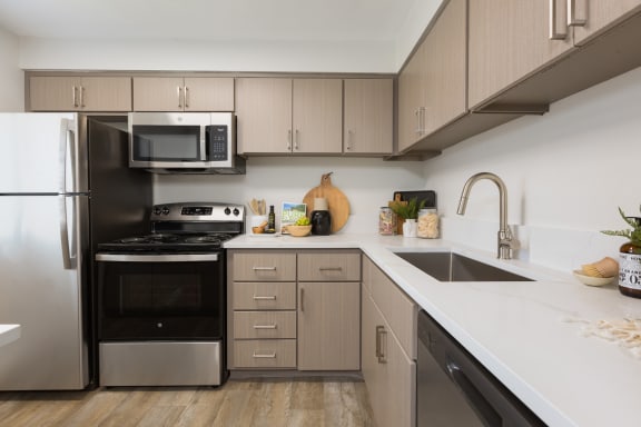 a kitchen with white countertops and stainless steel appliances