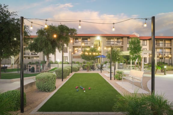 a rendering of an apartment complex with a lawn and seating area