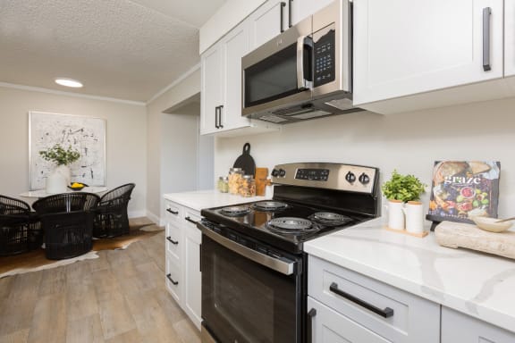 a kitchen with white cabinets and a black stove top oven