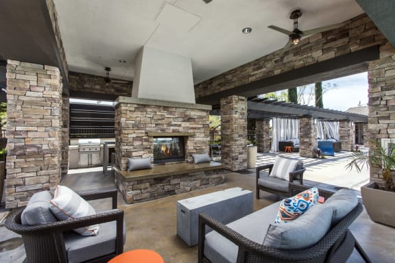Outdoor fireplace with seating at The Grove Apartments, Ontario, CA