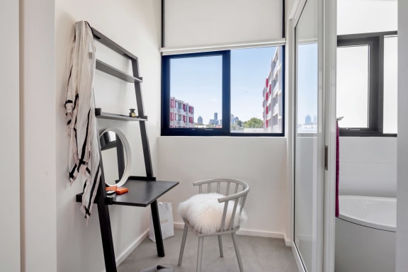 a small bathroom with a chair and a window