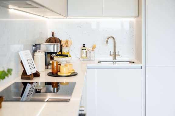 A kitchen counter with a sink, a coffee maker, and a few other items.