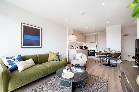 A living room with a green couch and a coffee table.