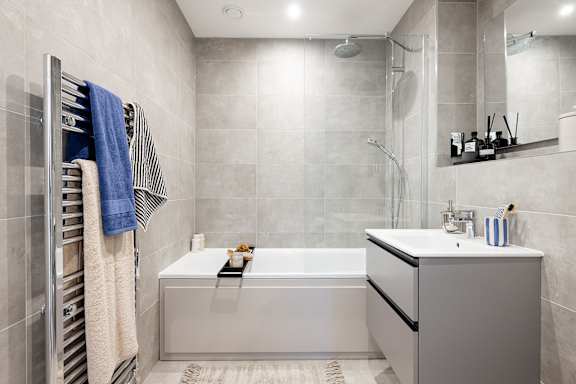 A modern bathroom with a white bathtub and a white sink.