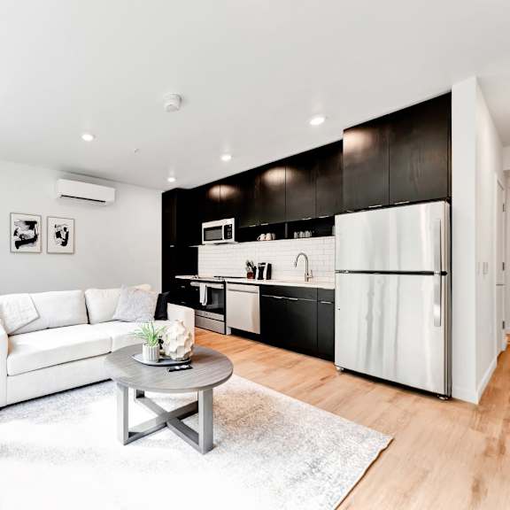 A modern kitchen with a stainless steel refrigerator, oven, and sink.