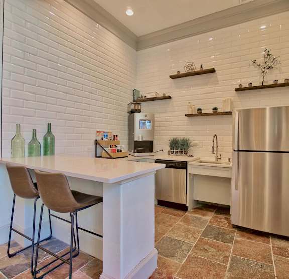 A kitchen with a white counter top and a stainless steel refrigerator.