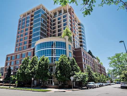 a large brick and glass building with trees in front of it