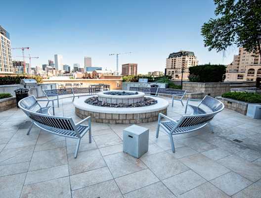 an outdoor terrace with a firepit and a view of the city
