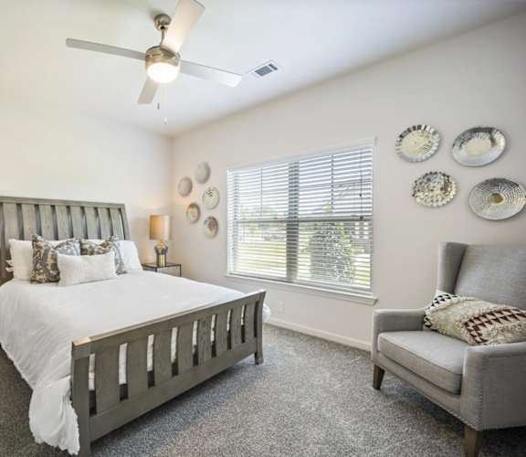 A bedroom with a large bed and a chair at The Maddox Apartments, Arkansas, 72719