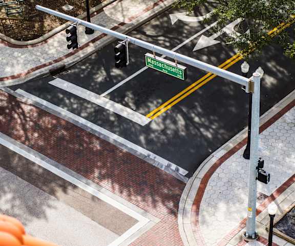 An aerial view of a street with a crosswalk and traffic lights.