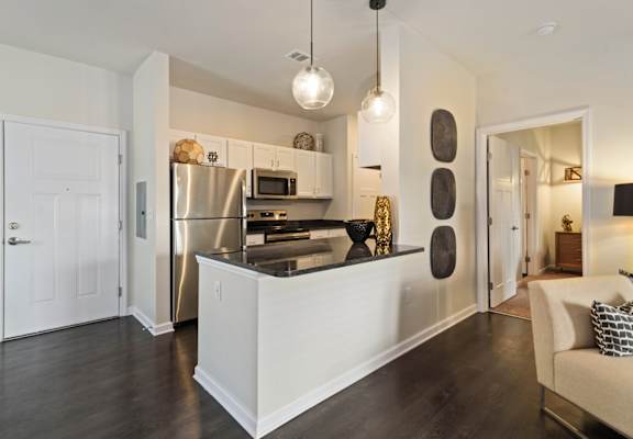 A modern kitchen with a white island and stainless steel appliances.