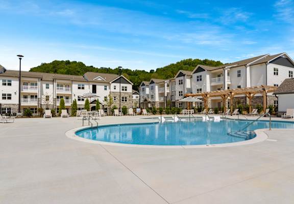 A large swimming pool in front of apartment buildings.