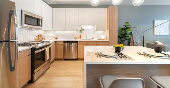 A modern kitchen with a dining table set for two.