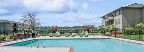 A swimming pool with apartment buildings in the background