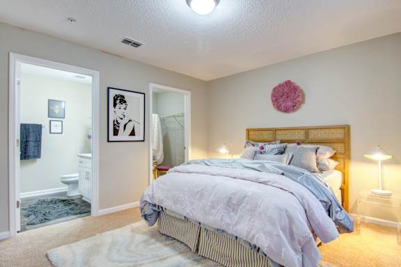 a bedroom with a bed and a bathroom with a toilet