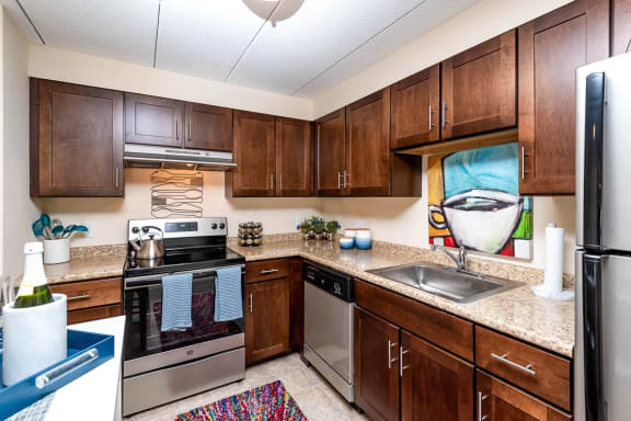 an empty kitchen with wooden cabinets and stainless steel appliances