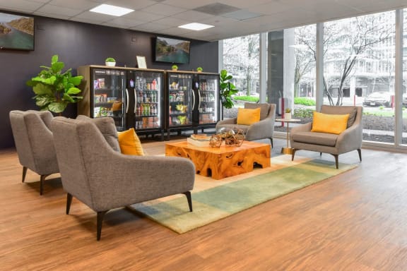 the lobby of a building with chairs and a coffee table