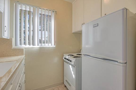 a kitchen with a sink and a stove and a refrigerator