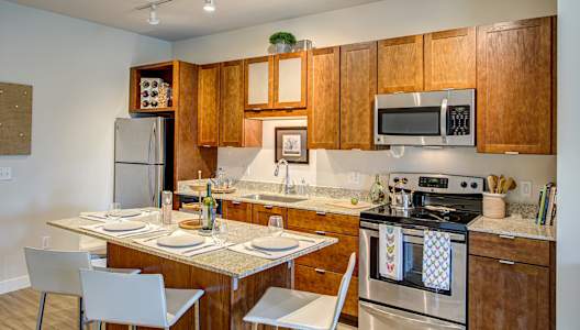 Kitchen with wooden cabinets and a stove top oven at Track 29 Apartments, Minneapolis, 55408