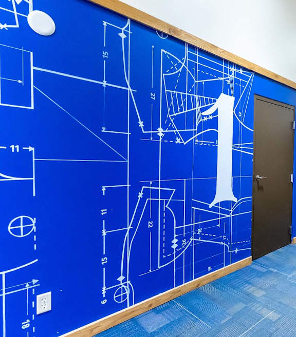 A hallway with a blue wall covered in architectural drawings.at Lee Lofts, Minneapolis, MN