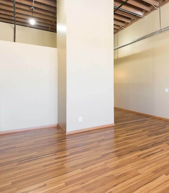 A room with wooden flooring and white walls.at Riverpoint Lofts, Des Moines, IA