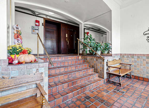 A hallway with a bench and a plant.