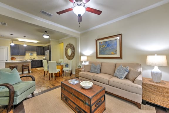 a living room with a ceiling fan and a large mirror at Hacienda Club Apartments in Jacksonville, FL