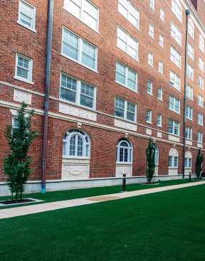a courtyard between two brick buildings with a green lawn at Residences at Forest Park, Saint Louis, 63108