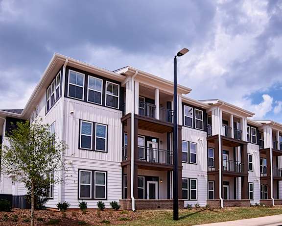 A modern apartment building with balconies and a street lamp in front at Beckett Farms Apartments, PRG Real Estate Management, Fort Mill