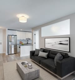 a living room with a couch and a table and a kitchen