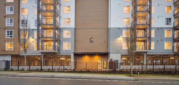 A large apartment building with a central entrance and balconies on the upper floors.