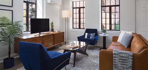 a living room with blue chairs and a brown couch