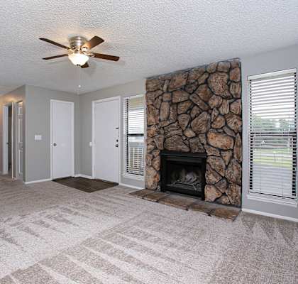 a living room with a fireplace and a ceiling fan