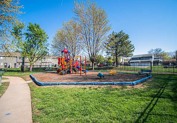 A playground with a blue slide and a red and yellow slide.