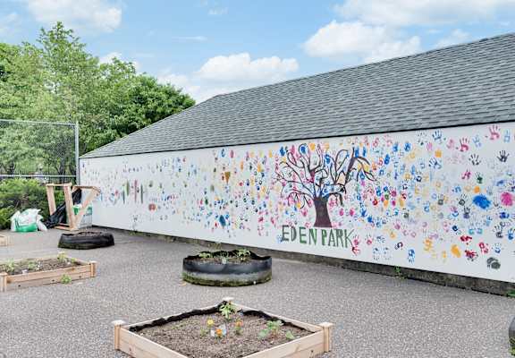 A wall with a tree and the words Eden Park on it.