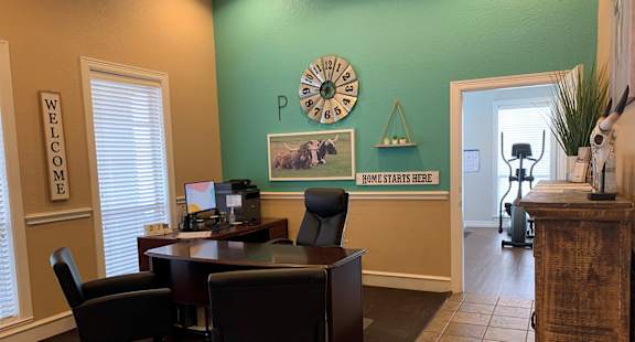 a desk with chairs and a clock on the wall