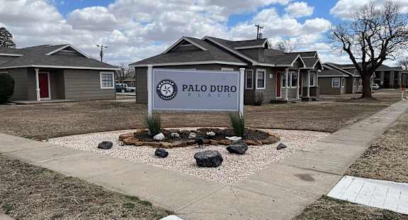 a subdivision sign in front of a row of houses
