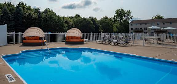 swimming pool with lounge chairs at Bloomfield Townhomes