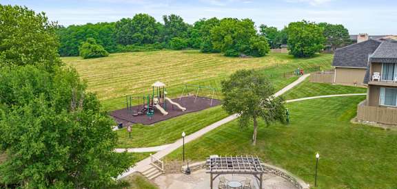 an aerial view of a park with a playground and a large field