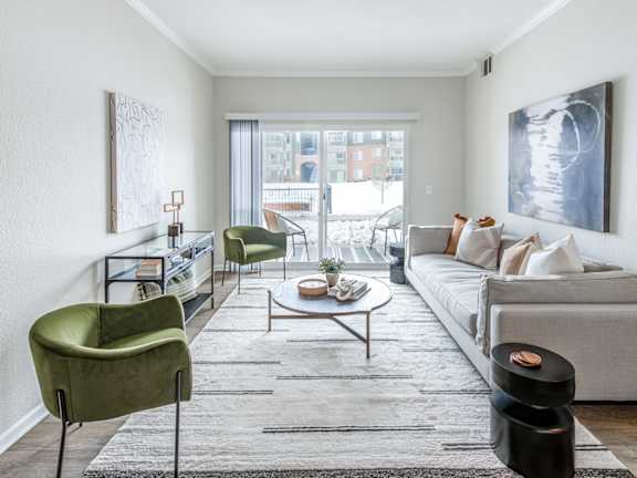 A living room with a grey couch, a green chair, and a coffee table.