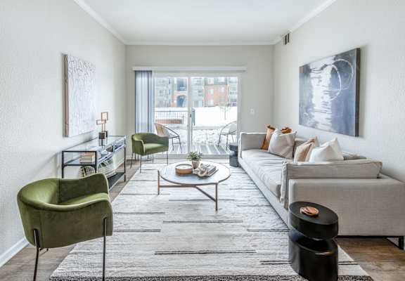 a living room with white walls and a large sliding glass door that leads to a balcony