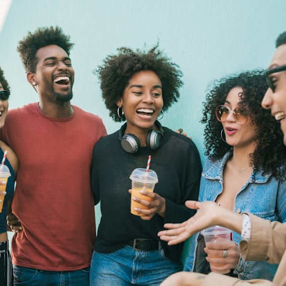 A group of friends are laughing and enjoying drinks together.