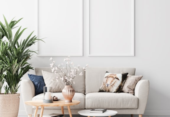 a living room with white walls and a couch with pillows