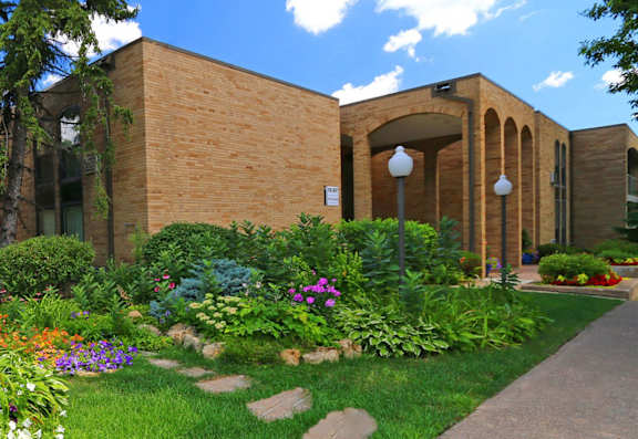 a garden in front of a brick building