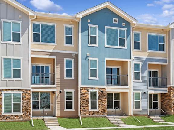 A row of townhouses with different colored exteriors.