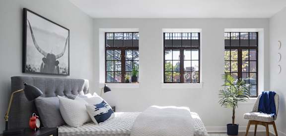 a bedroom with a bed and three windows