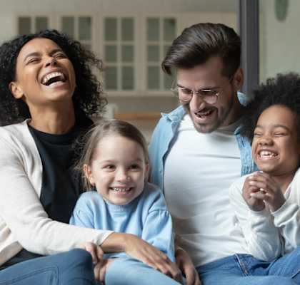 a family is sitting on a couch and laughing at The Entro at Midtown, Texas