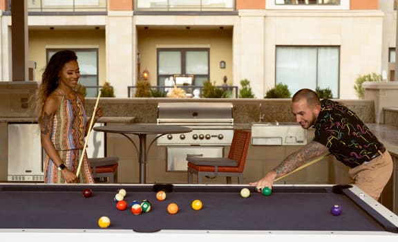 a man and a woman playing a game of pool